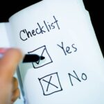 A notebook featuring a checklist with a marked 'Yes' box, captured in a close-up shot.